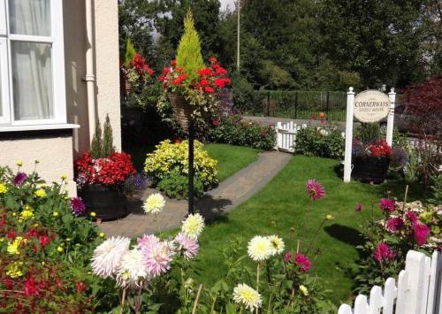 a garden of flowers in front of a house at Cornerways Bed & Breakfast in Oxford