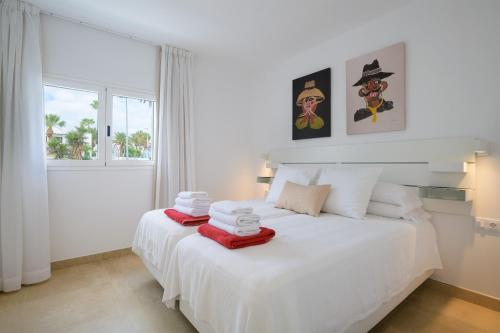 een slaapkamer met een wit bed en handdoeken bij Casa Anzuelo, Puerto del Carmen in Puerto del Carmen
