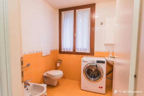 a bathroom with a washing machine and a toilet at Ca' degli Ulivi in Creazzo