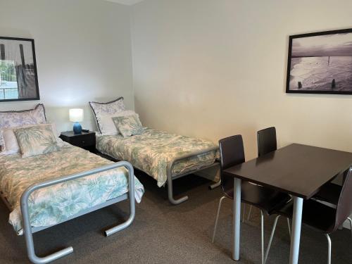 a room with two beds and a table and a desk at Waves 348 - Free WiFi - Late CheckOut - Garage in Cowes