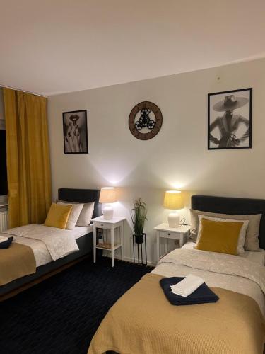 a bedroom with two beds and a clock on the wall at Noah Longstay Borås in Borås