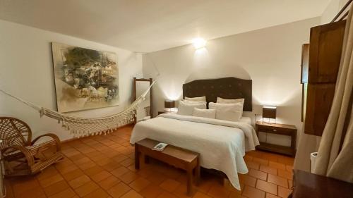 a bedroom with a large white bed and a hammock at Hotel Boutique Casa de Los Santos Reyes Valledupar in Valledupar