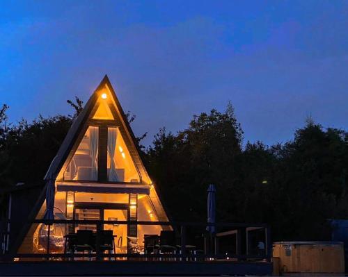 a triangular house with lights on it at night at A Green Nest in Suceava