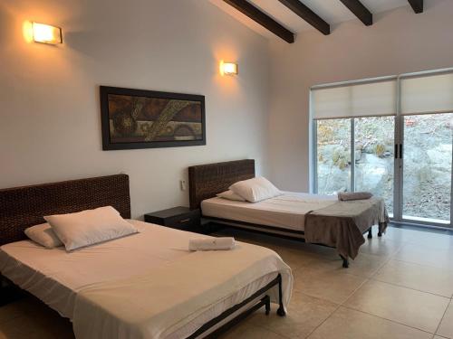 プラドにあるHotel La Islaの窓付きの客室で、ベッド2台が備わります。