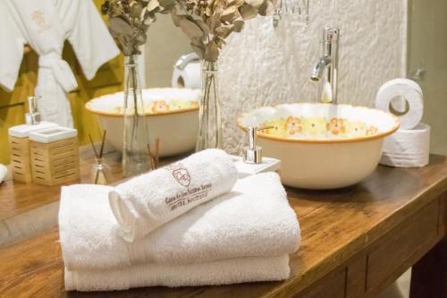 a bathroom with two sinks and towels on a counter at Hotel Boutique Casa de Los Santos Reyes Valledupar in Valledupar