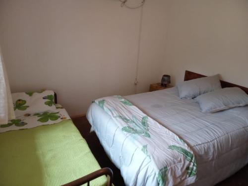 ein kleines Schlafzimmer mit einem Bett und einem Stuhl in der Unterkunft Apto. a dos cuadras del mar in Atlántida