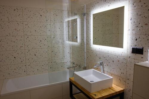 a bathroom with a sink and a tub and a window at Penzion pod Hazmburkem in Klapý