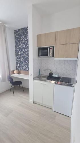 une cuisine avec un évier et un micro-ondes dans l'établissement Studio entièrement rénové proche gare, à Cambrai