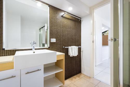 バイロンベイにあるByron Bay Beachfront Holiday Apartments Courtyard 1の洗面台とシャワー付きのバスルーム