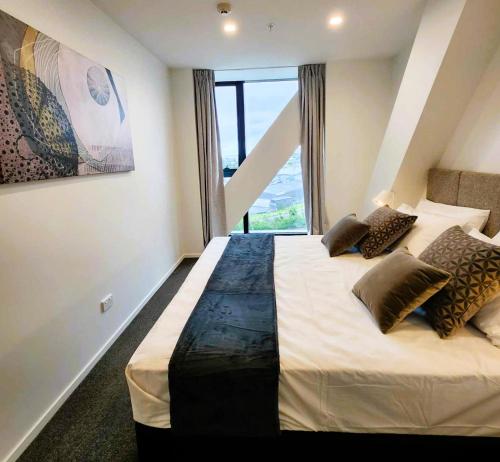 a bedroom with a large bed with a window at The Residences Ellerslie in Auckland