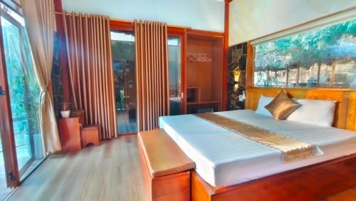 a bedroom with a bed and a window at Hang Mua Eco Garden in Xuân Sơn