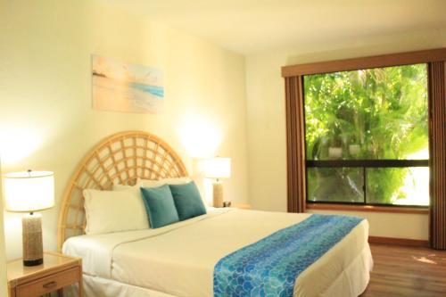 a bedroom with a bed and a large window at Shores at Waikoloa 112 - MCH in Waikoloa