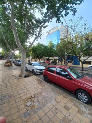 un coche rojo estacionado al lado de una calle en Centro Suit, en San Juan