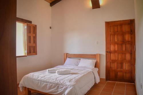 - une chambre avec un lit et une porte en bois dans l'établissement Villa Mipa Hotel y Restaurante, à Pueblo Bello