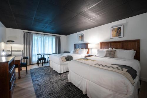 una camera d'albergo con 2 letti e una scrivania di Trailhead by Weekender 