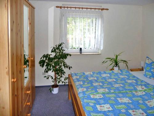 um quarto com uma cama e uma janela em Bungalow im Garten em Malchow
