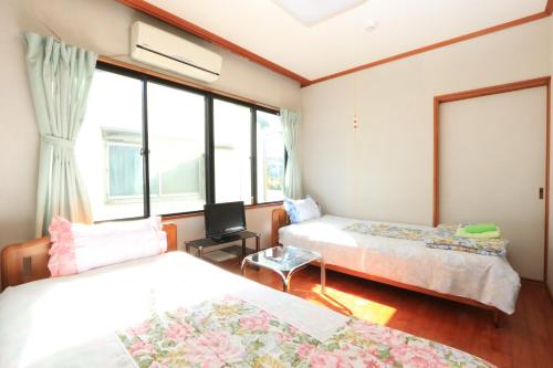 Minshuku Satomachi في ياكوشيما: غرفة نوم بسريرين ونافذة