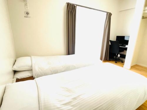 1 Schlafzimmer mit 2 Betten und einem Spiegel in der Unterkunft Condominium GOLF GOLF Tsuboya in Naha