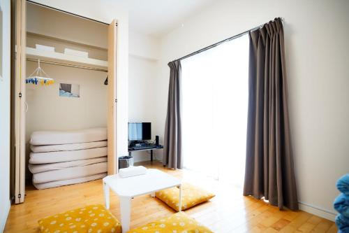 ein Wohnzimmer mit einem Spiegel und einem Bett in der Unterkunft Condominium GOLF GOLF Tsuboya in Naha