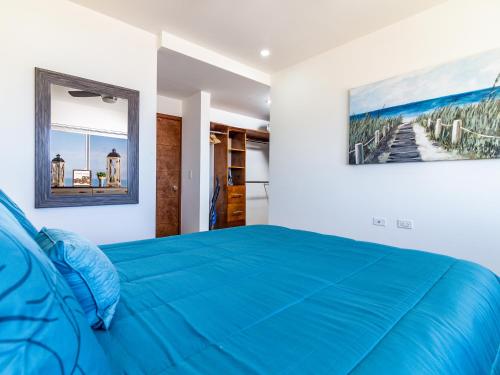 um quarto com uma cama azul e um quadro na parede em Cielomar em Tijuana