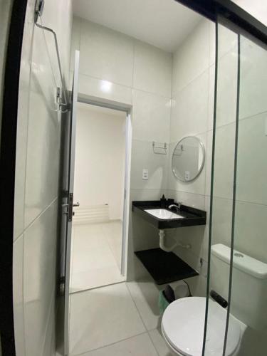 a bathroom with a shower and a sink and a toilet at Sol do Caribe Suítes in Maragogi