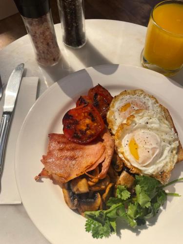 a plate of breakfast food with an egg and bacon at Victoria House Motor Inn in Croydon