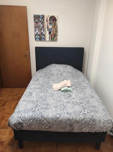 uma cama com um edredão azul e um par de sapatos em A Casa di Francesca em Lucca