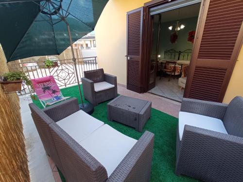 a patio with chairs and tables and an umbrella at I Fiori di AminA Le Begonie in Pietramelara