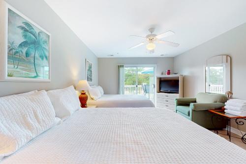 1 dormitorio blanco con 1 cama y TV en Relax at Middleton, en Calabash