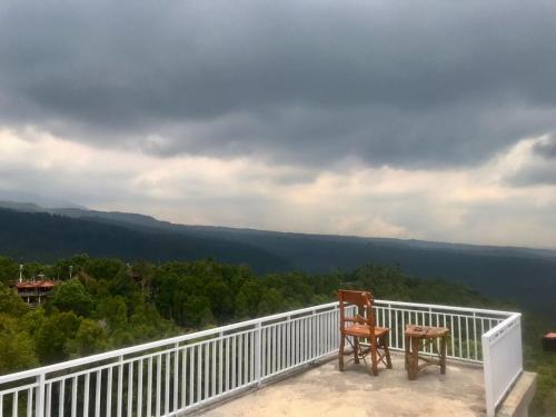two chairs sitting on a balcony with a view at Munduk Sena in Munduk