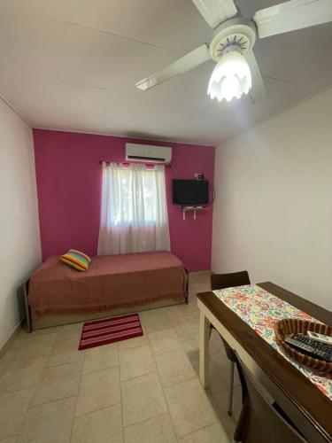 a small bedroom with a bed and a table at Bungalows palmar in Chajarí