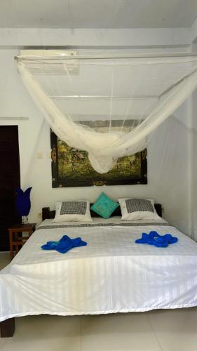 a large white bed with two blue towels on it at D Jana in Amed