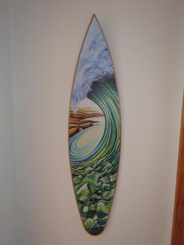 a mirror hanging on a wall with a painting on it at Rangiputa Moana in Karikari Peninsula