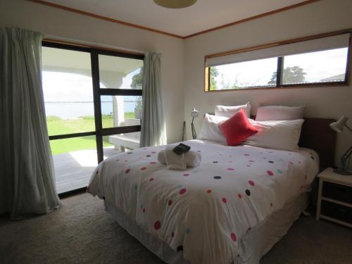 a bedroom with a bed with a teddy bear on it at Rangiputa Moana in Karikari Peninsula