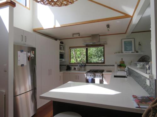 a kitchen with a white counter top and a refrigerator at Rangiputa Moana in Karikari Peninsula