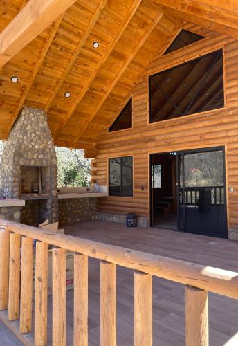 a porch of a log cabin with a wooden deck at Cabañas Sierra Grande in Santiago