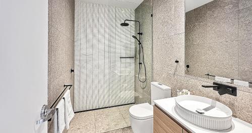 a bathroom with a shower and a toilet and a sink at Direct Collective - Bli Bli Suites in Bli Bli