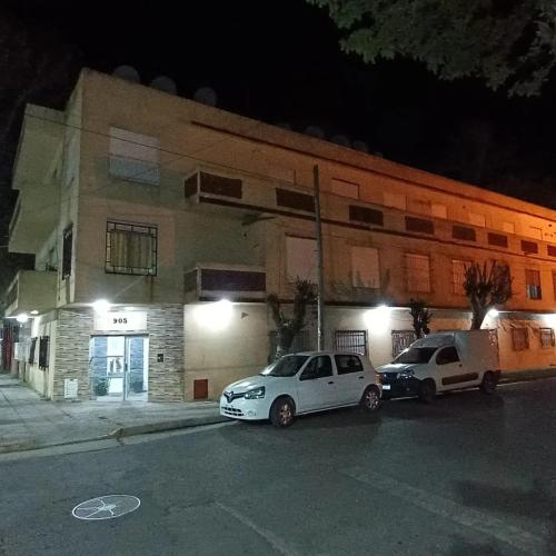 two cars parked in front of a building at night at Departamento en La Costa-Santa Teresita in Santa Teresita
