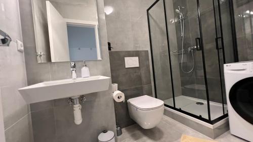 a bathroom with a toilet and a sink and a shower at Air conditioned 1 room Apartment Vienna Gate, 3 in Bratislava