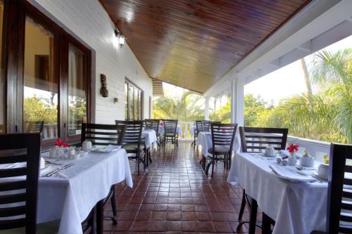 a restaurant with tables and chairs with white tablecloths at St. Lucia Wetlands Guest House in St Lucia