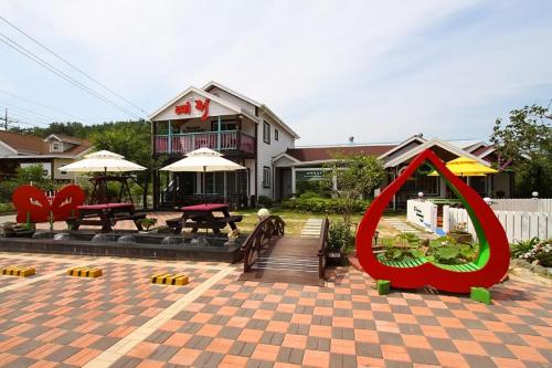 a patio with tables and umbrellas in front of a house at Yejeon Pension in Gyeongju