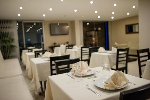 ein Esszimmer mit Tischen und Stühlen sowie weißer Tischwäsche in der Unterkunft Hotel Convencion in Trujillo