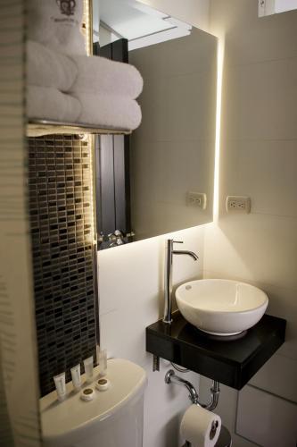 a bathroom with a sink and a toilet and a mirror at Hotel Convencion in Trujillo