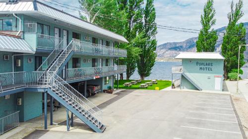 a building with stairs next to a body of water at Poplars Motel on the lake in Osoyoos