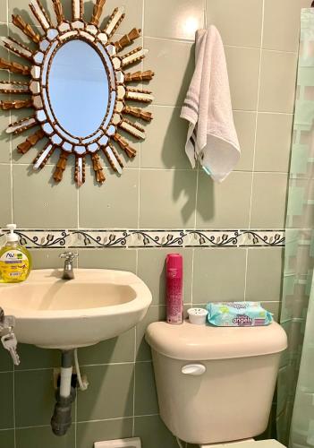 a bathroom with a sink and a toilet and a mirror at La Casa de Tía Ana in Ríohacha