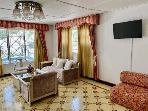 a living room with a couch and a tv at La Casa de Tía Ana in Ríohacha