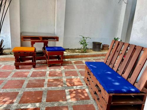 two chairs and a bench and a piano in a courtyard at La Casa de Tía Ana in Ríohacha