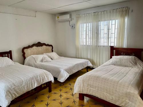 um quarto com 2 camas e uma janela em La Casa de Tía Ana em Ríohacha