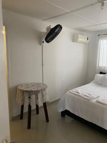 a room with a bed and a table and a lamp at La Casa de Tía Ana in Ríohacha