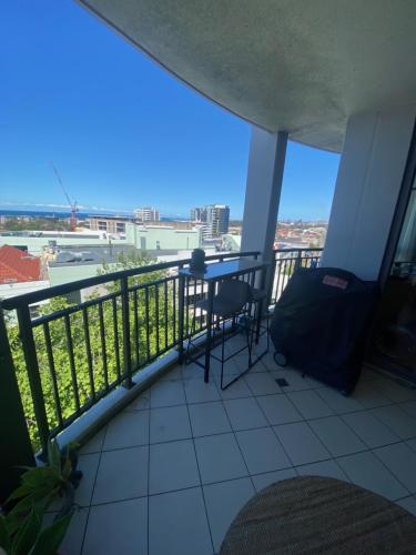 a balcony with a table and a view of the city at It's Paradise Here, Private Room with Breakfast and 2 cats in Wollongong